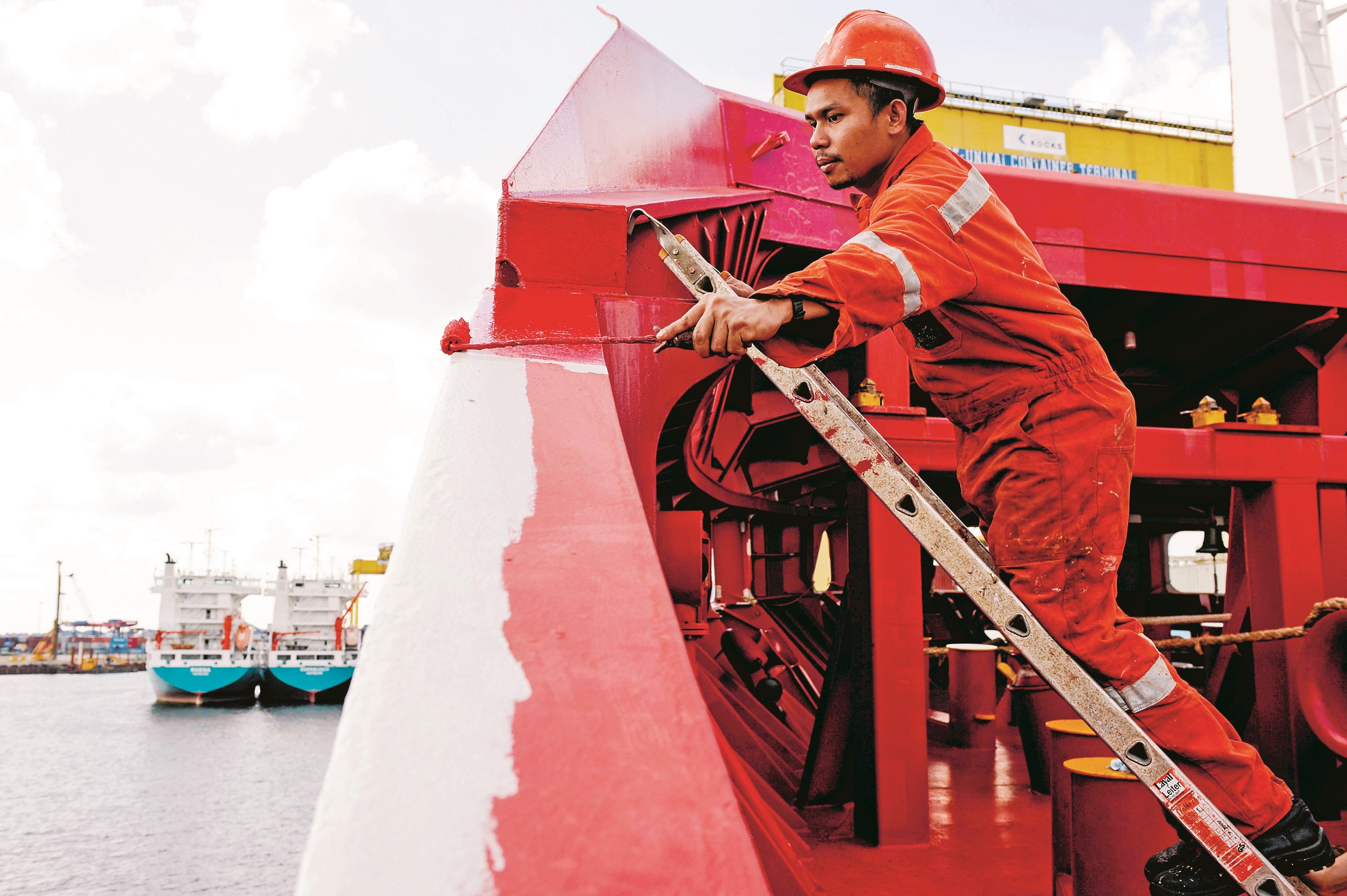 A Filipino seaman works on German cargo vessel MV Merwedijk in Hamburg harbour, Germany. Photo: Alamy